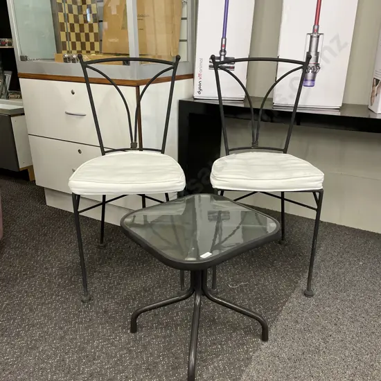 Ornate Metal 3 Piece Outdoor Set. 2 chairs with cream fabric squabs and glass top table