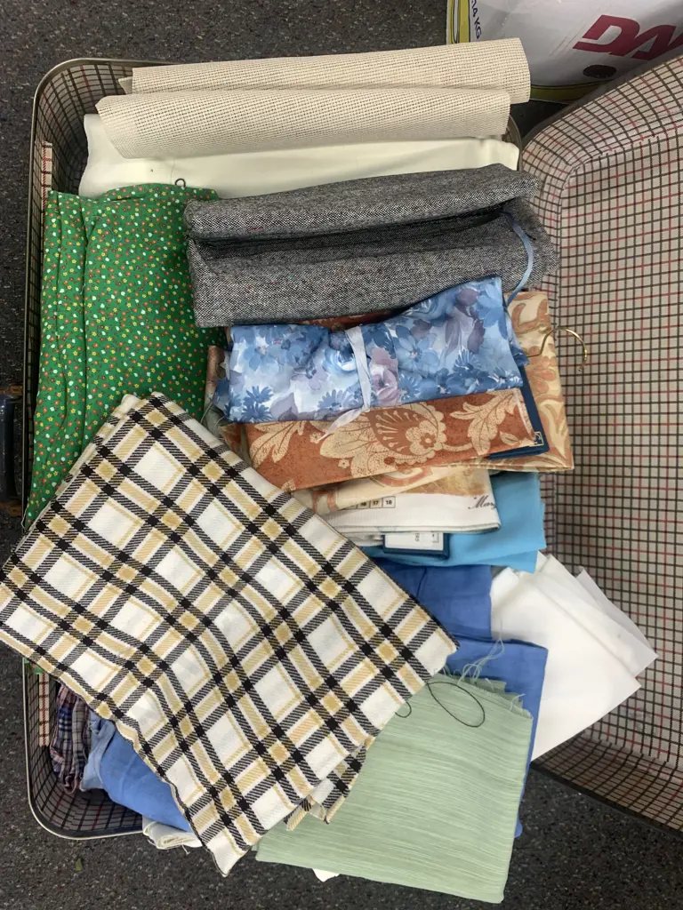 Blue Suitcase With Assorted Fabric Pieces Image 1++