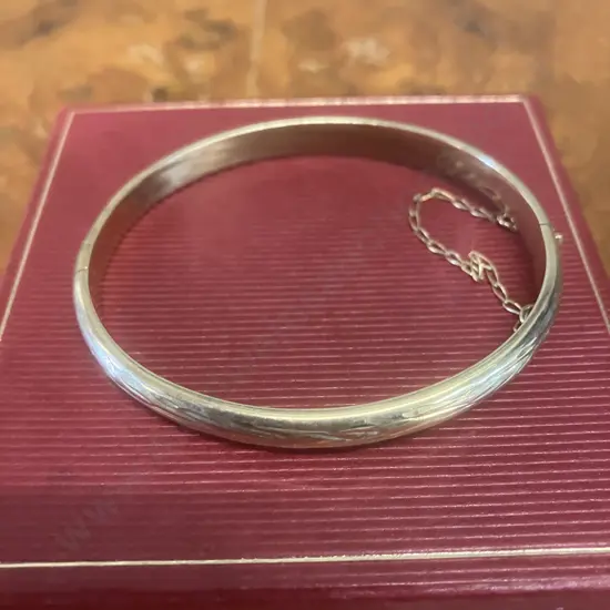 Stamped 375 Gold Hinged 'Bark Pattern' Bangle With Safety Chain