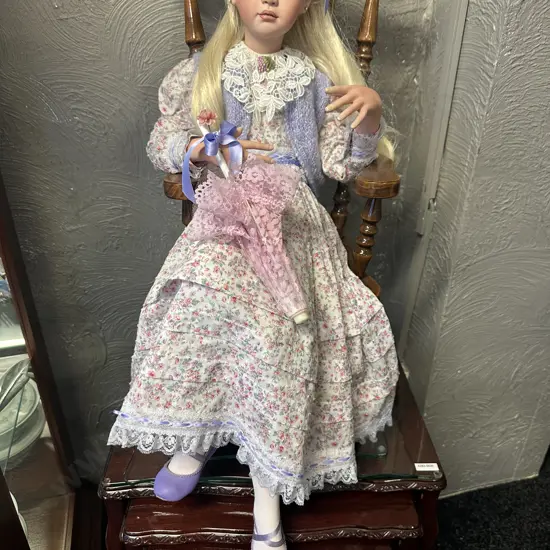 Vintage Porcelain Doll Sitting On Minature Colonial ChairWith Legs Crossed Dressed By Jan Mclean Designers