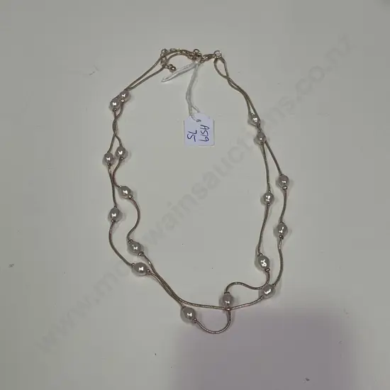 Rose gold coloured necklace with intersecting pearl type beads