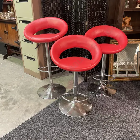Trio of Red Leatherette Adjustable Height and Swivel Bar Stools