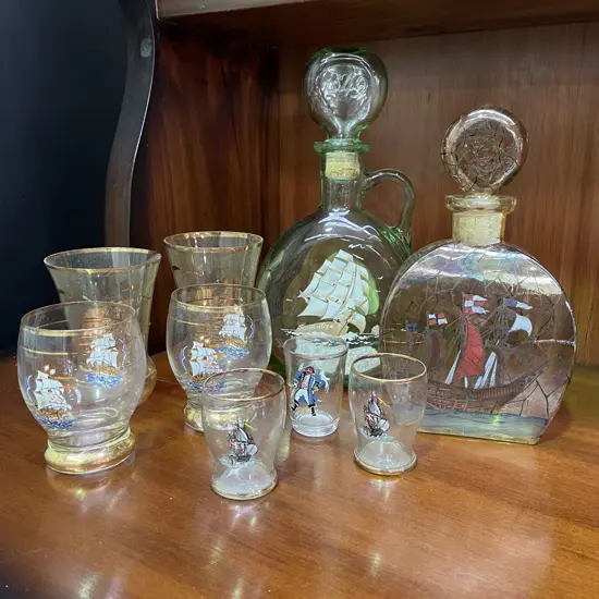Two Vintage Glass Decanters with handpainted and gilded ship decoration. With assorted Ship themed glasses.