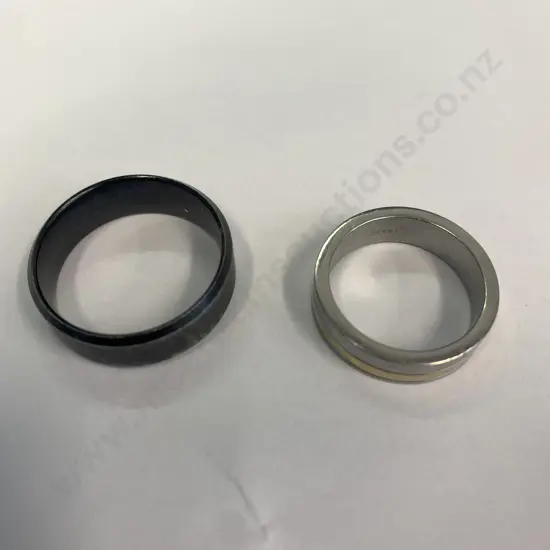 Pair of Mens Rings, one silver coloured engraved with 'Chisel Steel' and one Black
